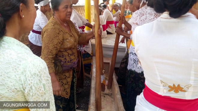 ibu-ibu memainkan musik dengan alu dan lesung