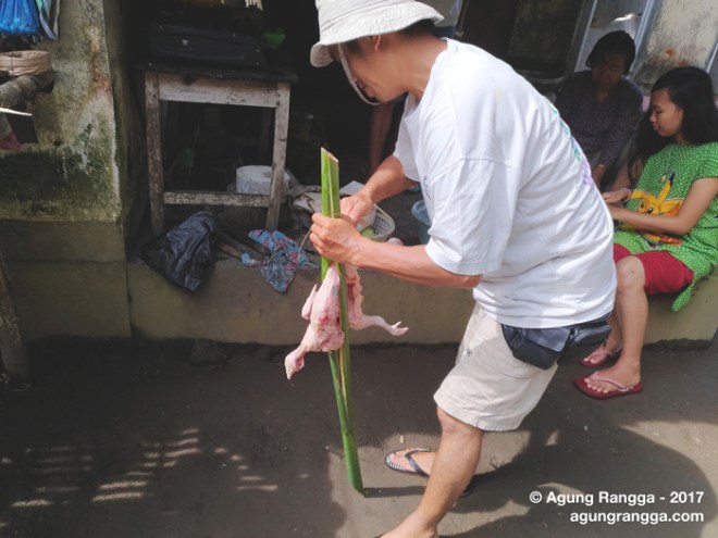 Aji Putu sedang mempersiapkan ayam untuk dibakar