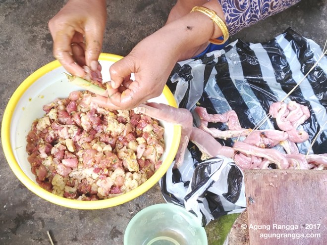 memasukkan potongan daging ke usus babi
